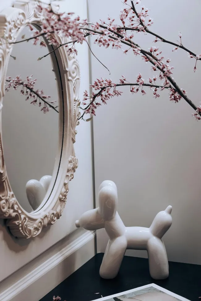 Weiße Nischen mit Ästen und reflektierenden Dekorationsobjekten als Styling-Akzente