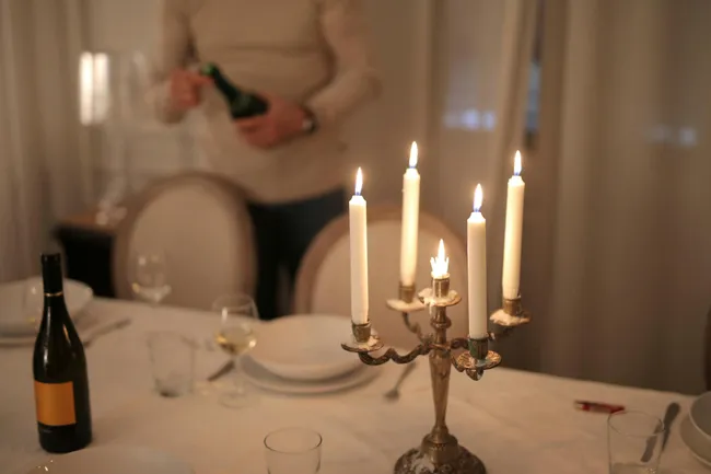 Gem&uuml;tliches Esszimmer mit Kerzen und warmem Licht &uuml;ber gedecktem Tisch
