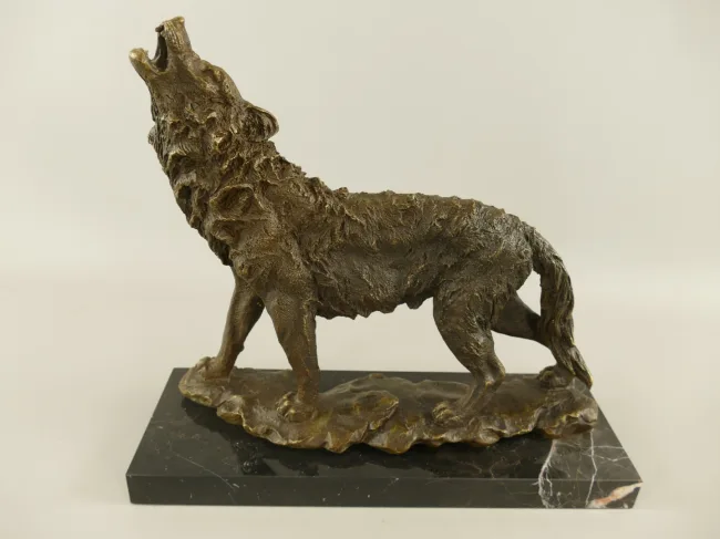 Bronzener heulender Wolf auf Felsboden – naturalistische Wolfsskulptur auf Marmorsockel